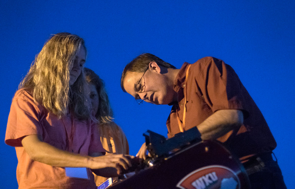 SKyTeach Master Teacher Rico Tyler helps NSCF Scholars Melissa Harris (left) of Warren East Middle School in Bowling Green and Amy Long from Sanford Middle School in Opeika, Alabama, take a picture of the moon using their smartphones and a telescope Wednesday, June 8. (Photo by Sam Oldenburg)
