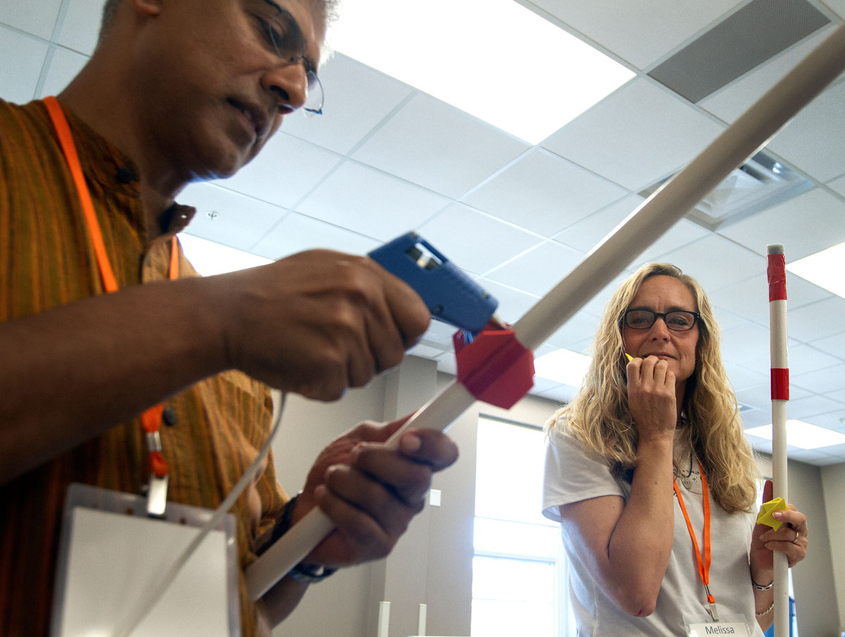 Santosh Zachariah from the Evergreen School in Shoreline, Washington, attaches foam fins to his rocket while Melissa Harris of Warren East Middle School in Bowling Green waits to use the hot glue gun Tuesday, June 7. The simple rockets took about thirty minutes to construct. (Photo by Sam Oldenburg)