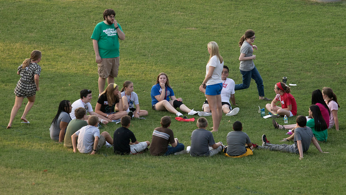 Counselor Matt Owen leads campers in a game of Duck, Duck, Goose as an ice-breaker activity Sunday, June 12, on South Lawn. (Photo by Sam Oldenburg)