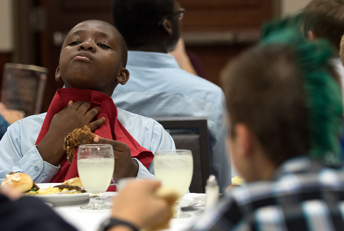 Ezekiel Salama of Shelbyville tries to block potential food spills from staining his dress shirt during the SCATS banquet Thursday, June 23. (Photo by Sam Oldenburg)