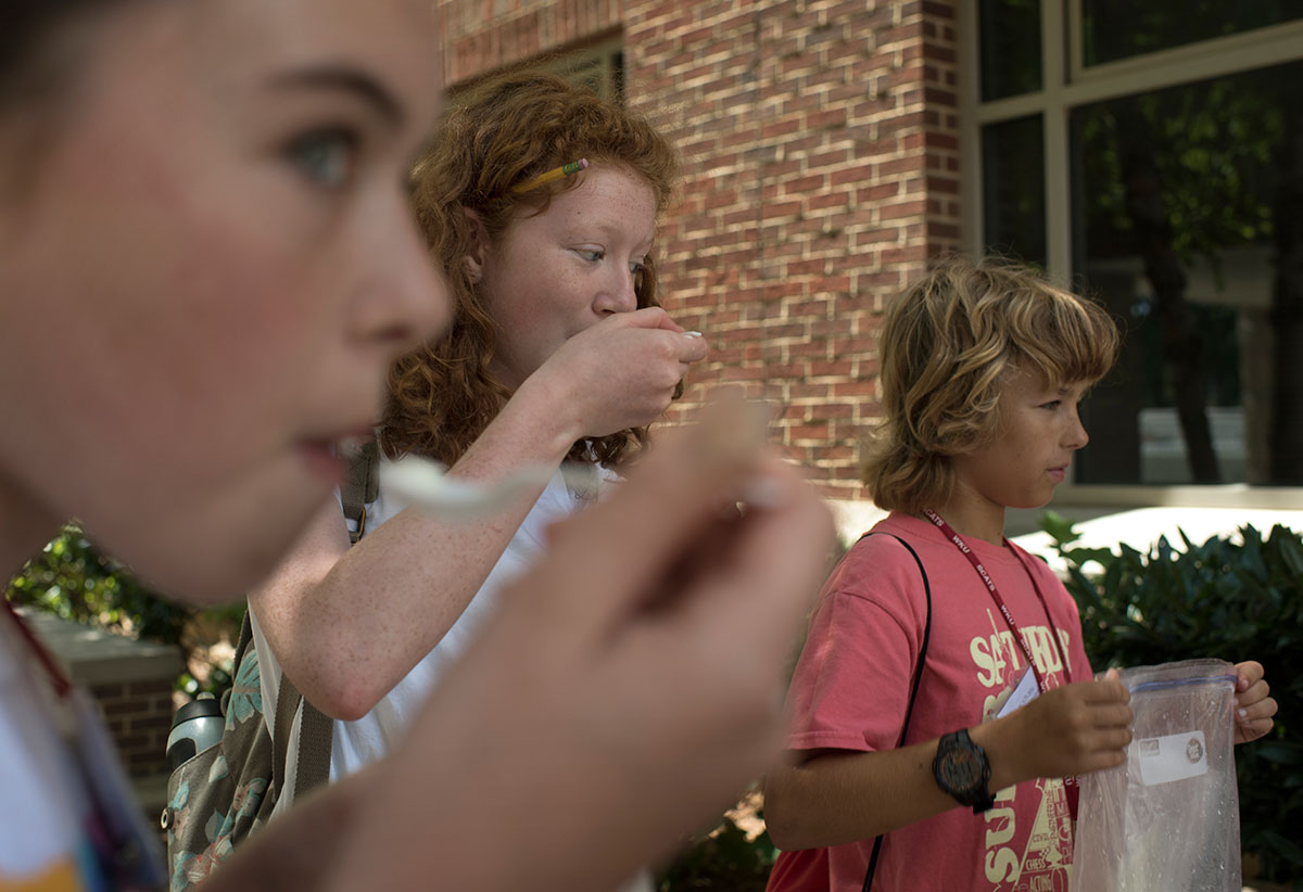 Maggie-Beth Bacon ( form left) of Owensboro, Taylor Galavotti from Lexington, and Simon Forsting from Louisville eat the ice cream they made during Chemistry of Everyday Friday, June 17. (Photo by Tucker Allen Covey)
