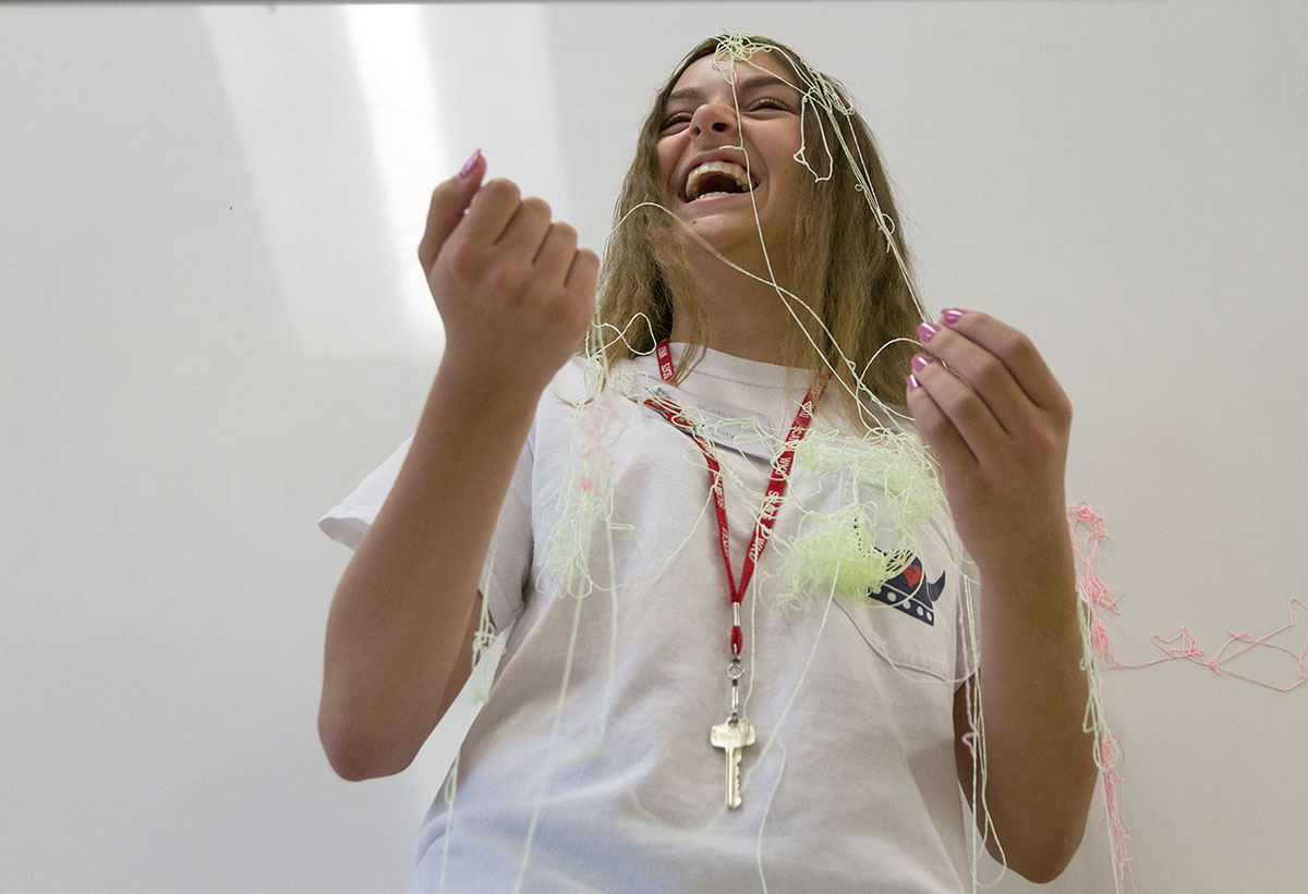Emily Slaven from Louisville laughs after being sprayed with silly string while delivering an extemporaneous speech in Public Speaking Friday, June 17. The teacher, Kevan Brown, sprayed students if they used any filler words, such as like, and, or um. (Photo by Sam Oldenburg)