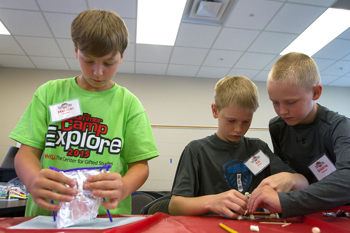 Malacki Murphy (from left), Eli Finley, and Quentin Grieshop work together to construct structures during Math at Camp Innovate Wednesday, June 8. After building the structures, they tested their stability with the wind from a hair dryer. (Photo by Sam Oldenburg)