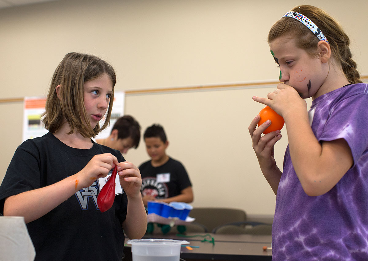 Ainsley Stobaugh (left) and Keri Johnson inflate balloons to use while building a prototype for an their invention to solve a real-world problem Thursday, June 9, during Science at Camp Innovate. (Photo by Tucker Allen Covey)