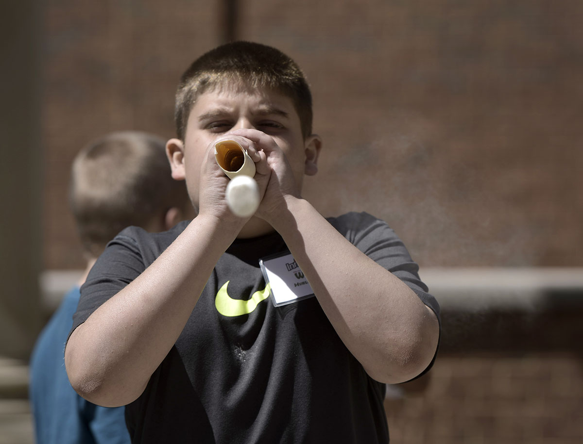 Will Hackbarth shoots a flour-covered marshmallow out of a tube during Science at Camp Innovate Tuesday, June 7. The students measured the distance traveled by their marshmallows and explored what could be done to make them travel further. (Photo by Tucker Allen Covey)