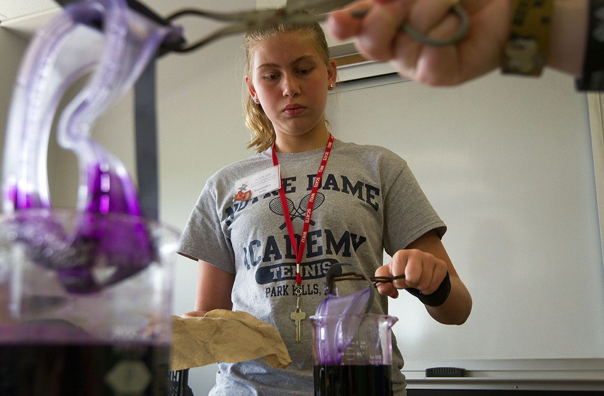 Samantha Bailey of Villa Hills dips her goggles in purple dye during Chemistry of Everyday Monday, June 13. The students dyed the goggles the colors of their choice and will use the same goggles throughout SCATS before taking them home with them after camp. (Photo by Sam Oldenburg)