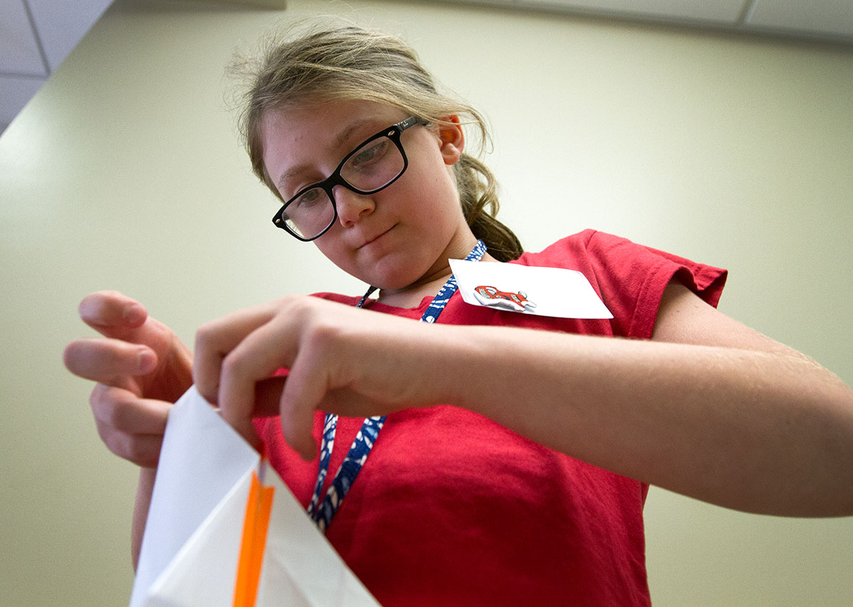 Emma Haupt of Columbia, Missouri, makes adjustments to her paper airplane in Creative Problem Solving Monday, June 13. (Photo by Sam Oldenburg)