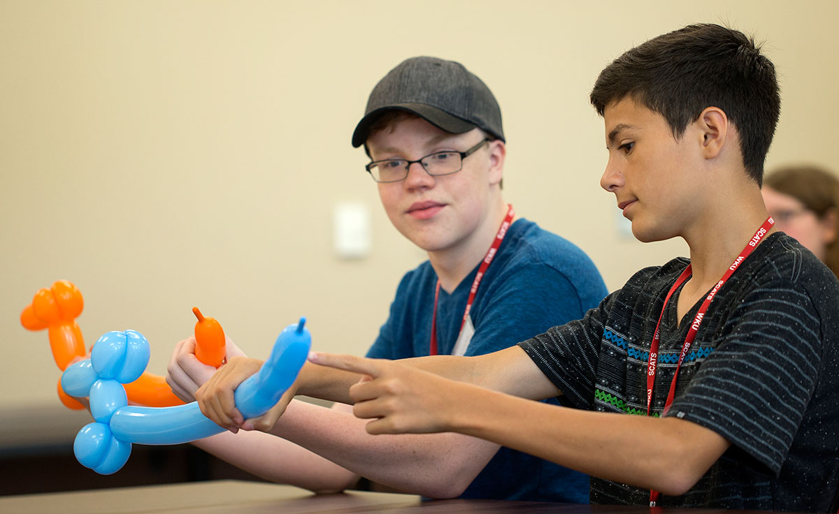 Griffin Salsman (left) of Springfield, Tennessee, and Austin Wallace of Bowling Green learn how to create balloon dogs during Clowning on Monday, June 13. (Photo by Tucker Allen Covey)