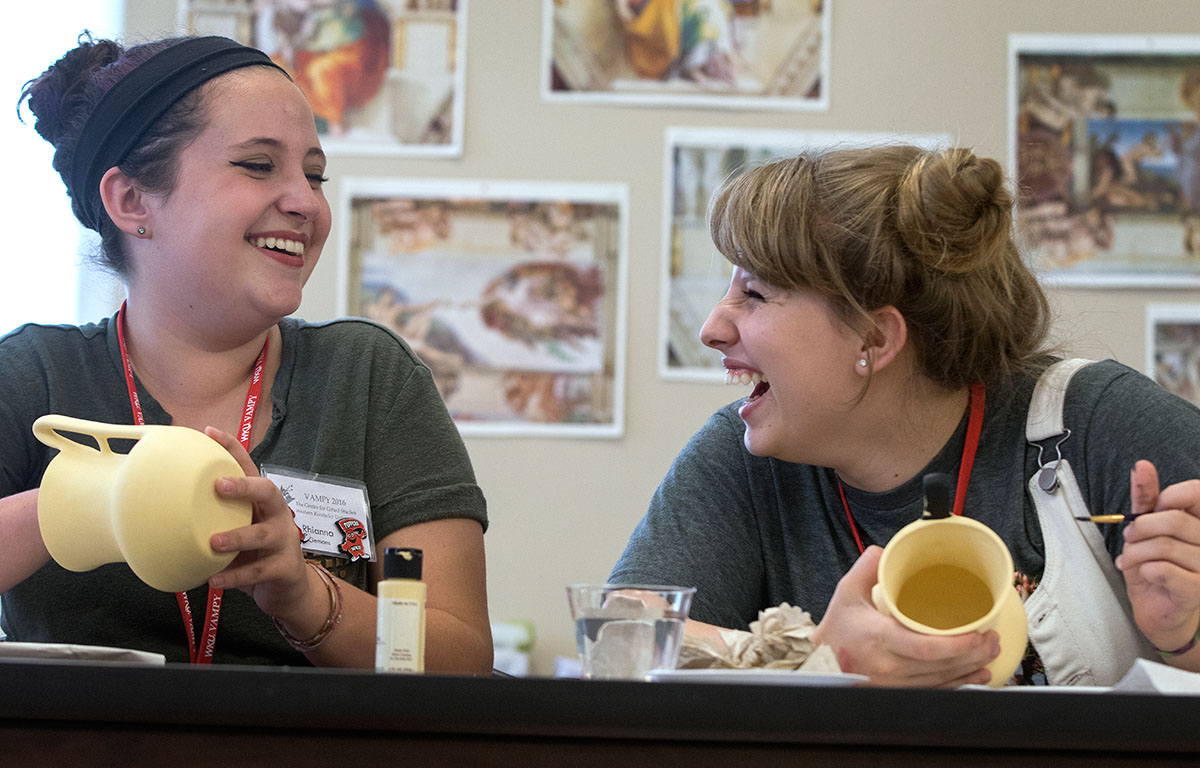 Rhianna Clemons (left) of Elizabethtown and Rhianon Hussung of Louisville share a laugh while painting drinking vessels in the style of ancient Greeks during Humanities Thursday, June 30. (Photo by Sam Oldenburg)