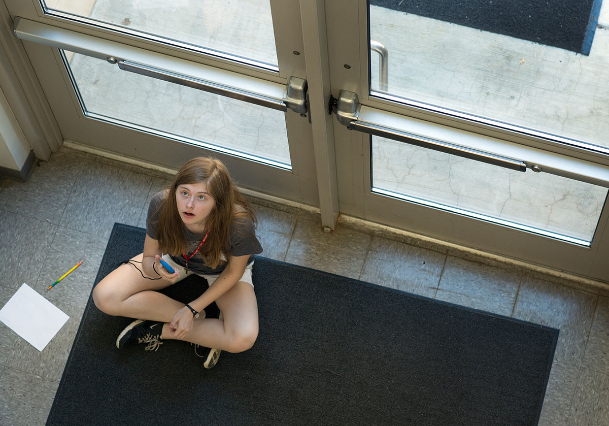 Kennedy Pendleton of Hopkinsville watches and records times as her group members in Problems You Have Never Solved Before drop paper spinners from the second floor balcony inside Snell Hall on Tuesday, June 29. (Photo by Tucker Allen Covey)