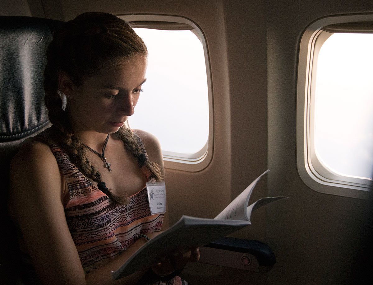 Chloe Banaszak of Crestwood reads on the plane while flying from Nashville to Baltimore en route to a one-day field trip in Washington D.C. Wednesday, July 6. Chloe class, Nazi Germany and the Holocaust, visited the Holocaust Museum.  (Photo by Sam Oldenburg)