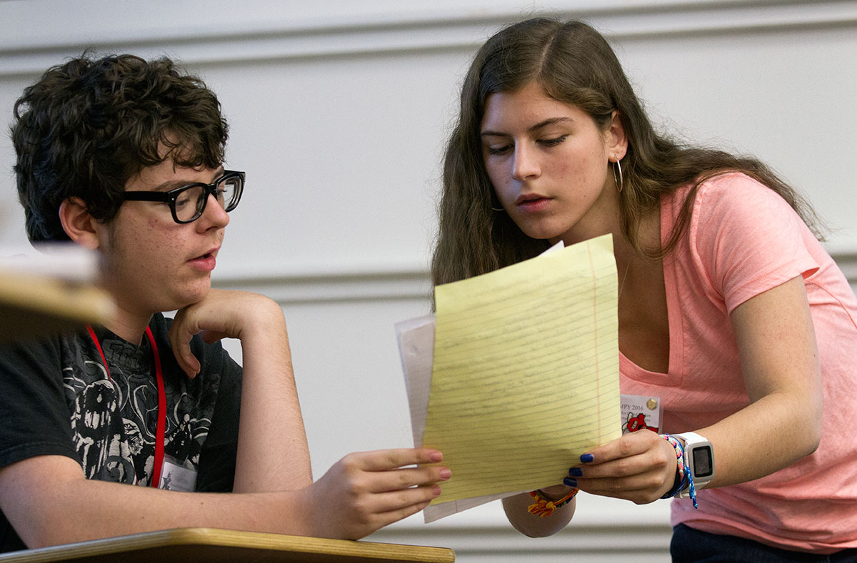 Christian Butterfield (left) of Bowling Green gives notes to his partner, Emily Jones of Lexington, as they debate in opposition to school uniforms in Competitive Forensics Tuesday, July 5. (Photo by Sam Oldenburg)