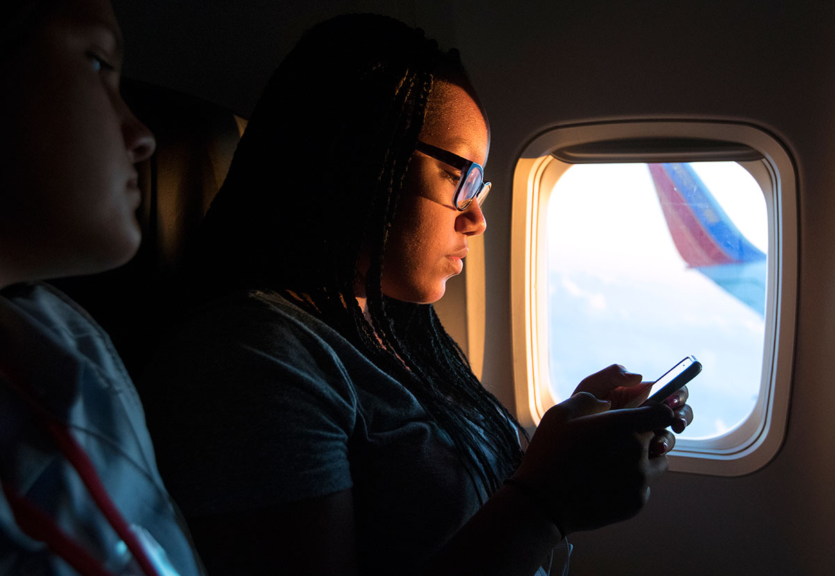 To'Nia Beavers of Bowling Green adjusts her music while flying toward the sunrise en route to Washington D.C. for a field trip to the Holocaust Museum Wednesday, July 6. The flight was To'Nia's first time on an airplane.  (Photo by Sam Oldenburg)
