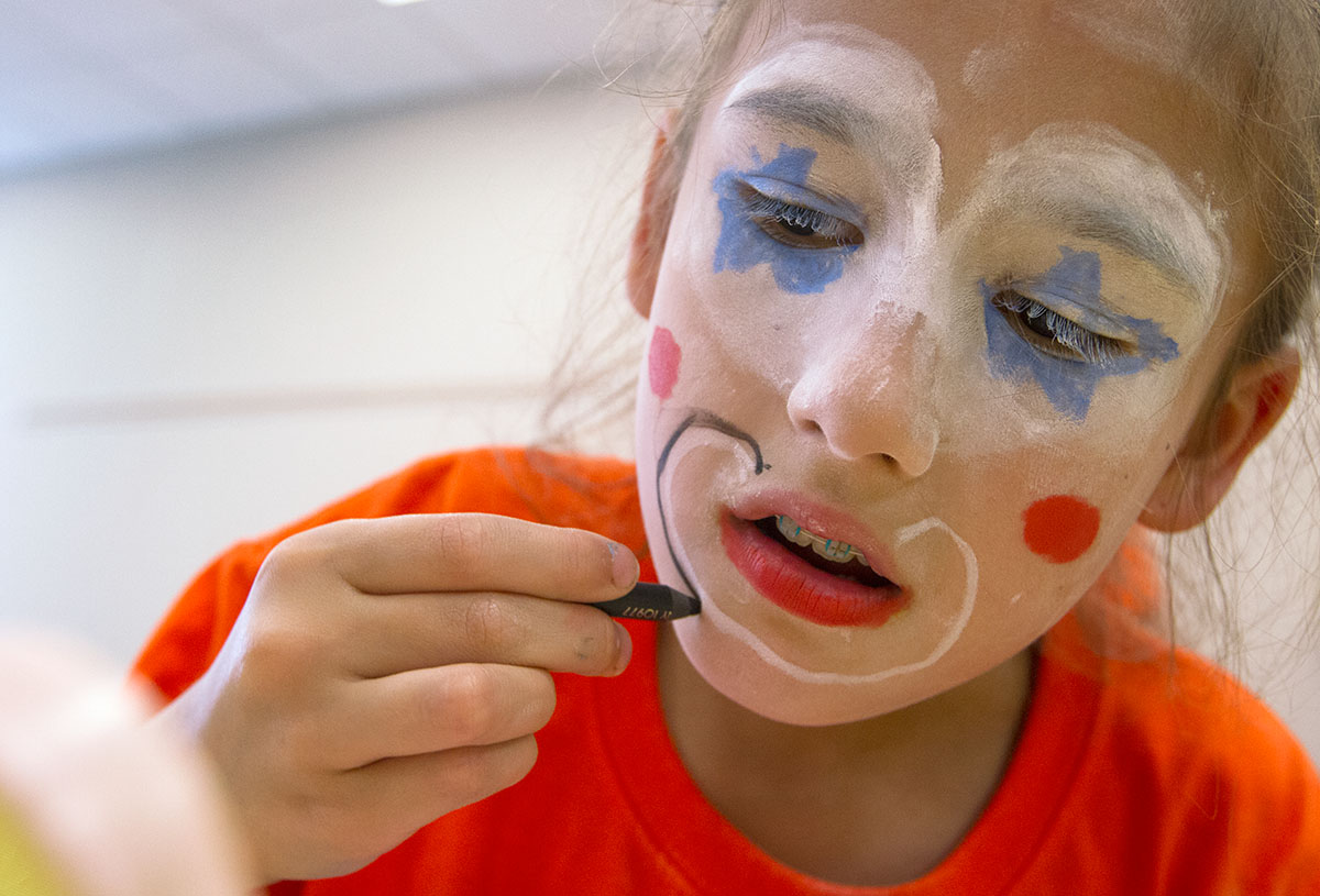 Natalie Kantosky applies makeup during Clowning Friday, July 15. Students designed their own clown faces before using makeup to put them on. (Photo by Sam Oldenburg)