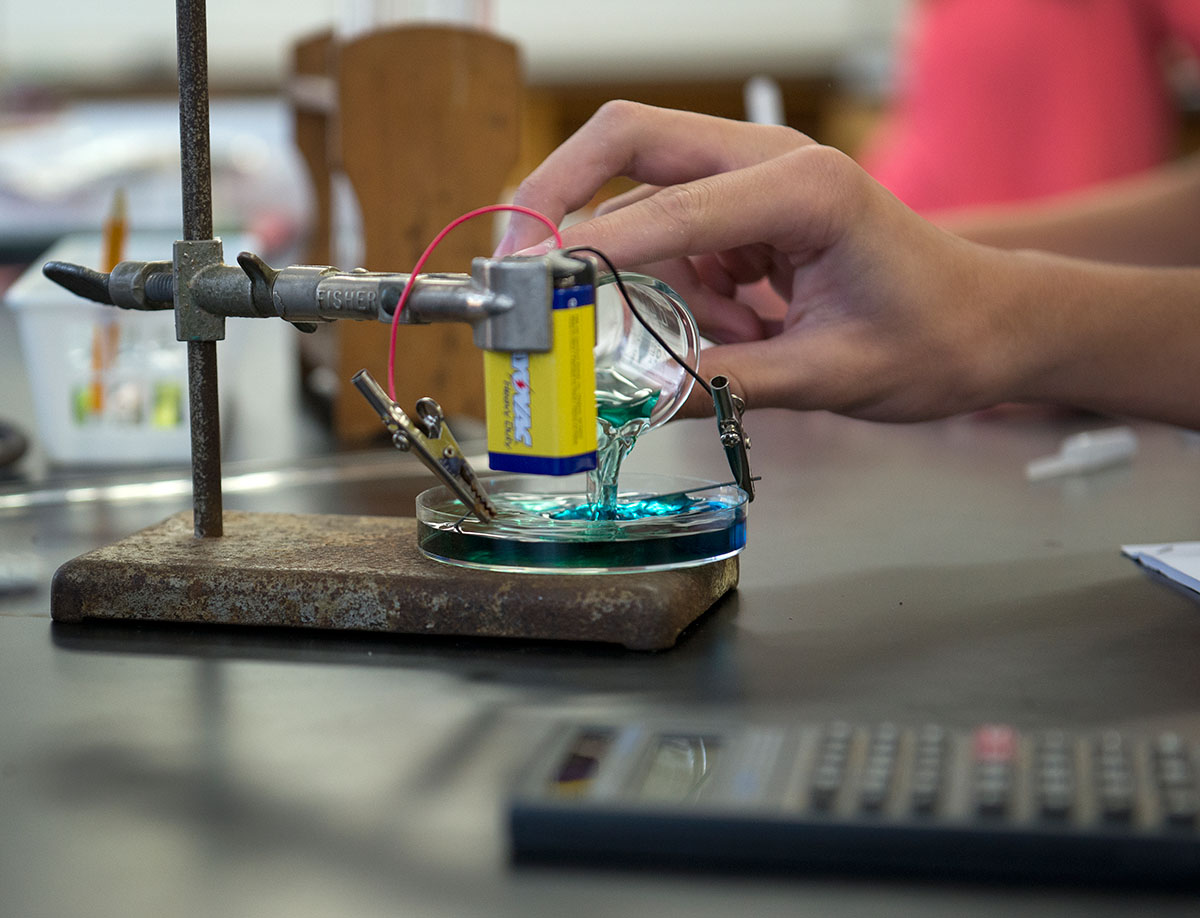 On Thursday, June 30, campers in Chemistry use the electric current from a battery to make the liquid being poured into the petri dish change colors. (Photo by Tucker Allen Covey)