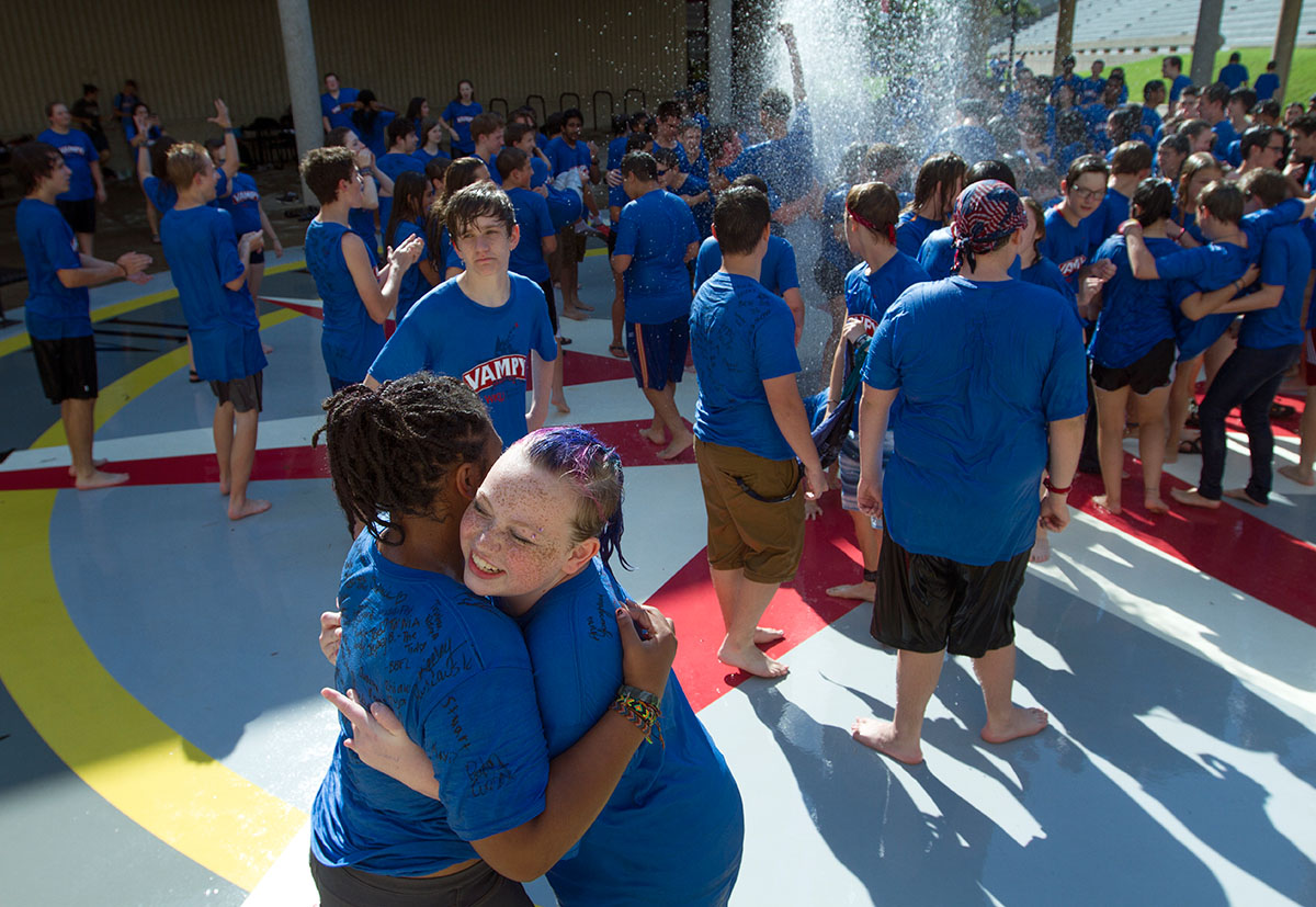 Ali Shackelford (left) and Evvie Cooley, both from Louisville, hug during the traditional fountain run outside Margie Helm Library Friday, July 15. (Photo by Sam Oldenburg)