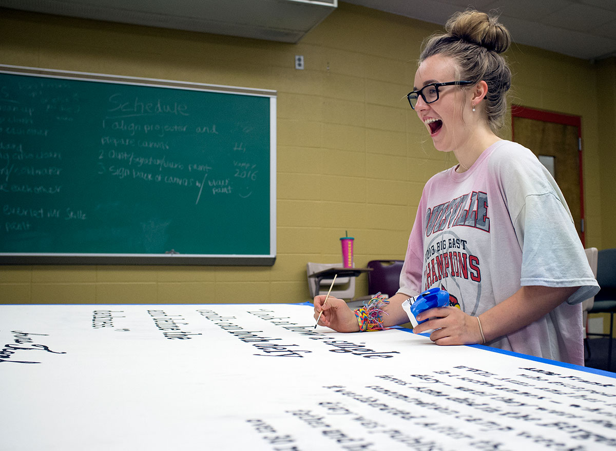 Madison Fleischaker from Louisville laughs while working on a mural with classmates in Nazi Germany and the Holocaust Tuesday, July 12. (Photo by Tucker Allen Covey)