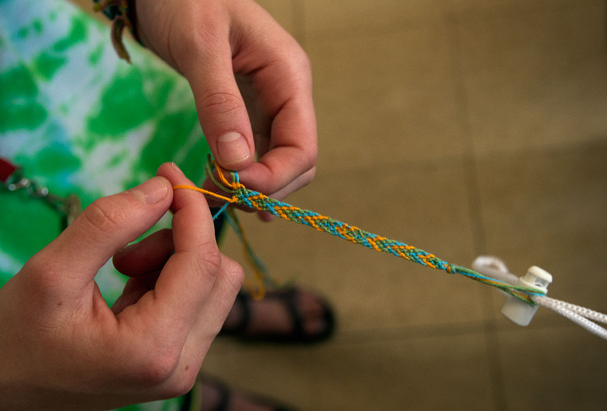 Kiersten Hamilton of Georgetown braids a friendship bracelet while waiting for her clothes to dry at Bryce's Bypass Laundromat Sunday, July 10. (Photo by Sam Oldenburg)