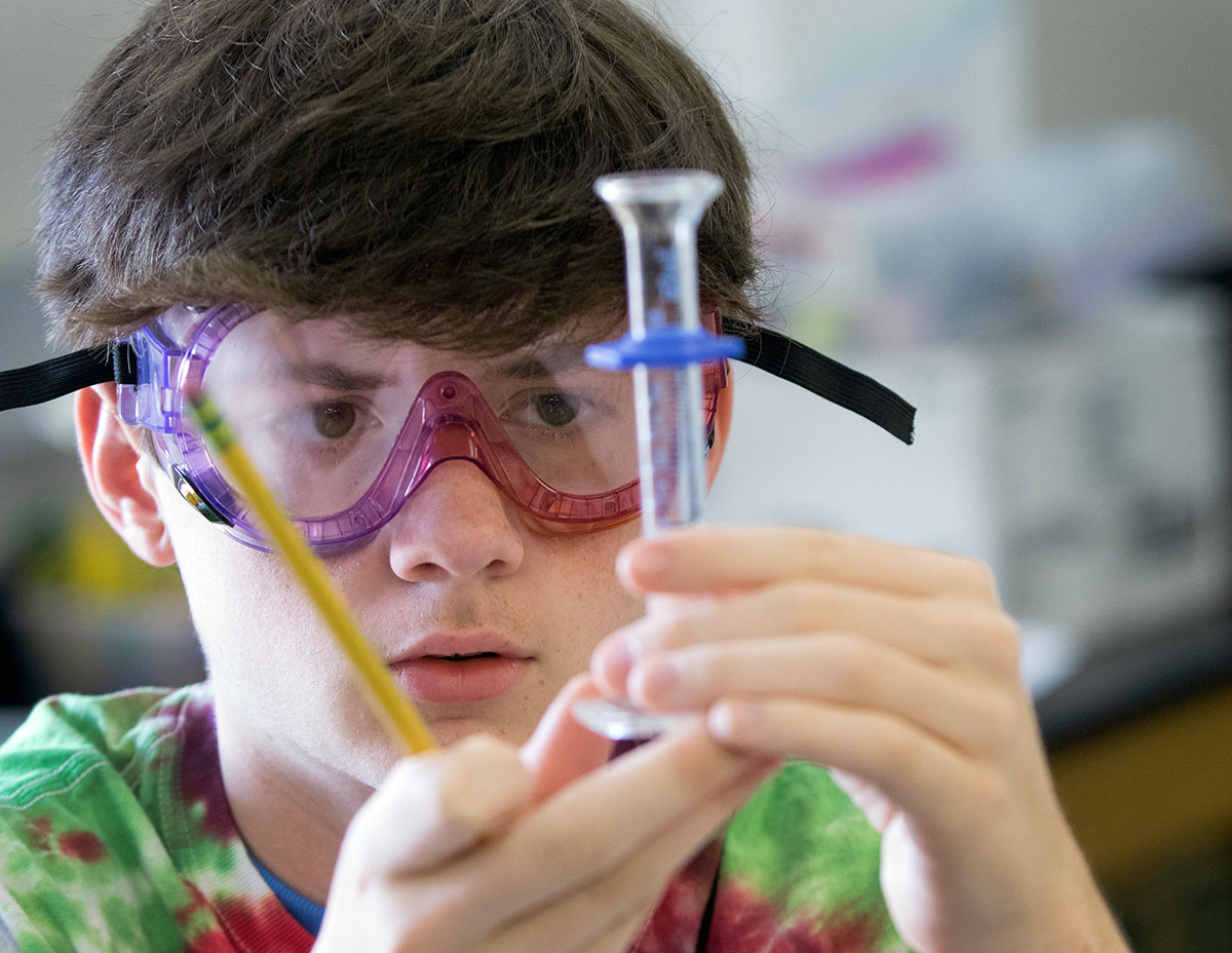 Jared Rodgers of Verona measures a liquid in Chemistry Friday, July 15. (Photo by Sam Oldenburg)