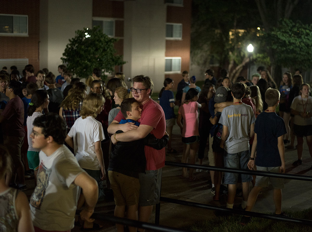 Sam Vitale (center) of Bowling Green hugs a fellow camper during Cryfest outside Northeast Hall Thursday, July 14. Held on the second-to-last night of camp, Cryfest gives campers an opportunity to start saying their emotional goodbyes. (Photo by Tucker Allen Covey)