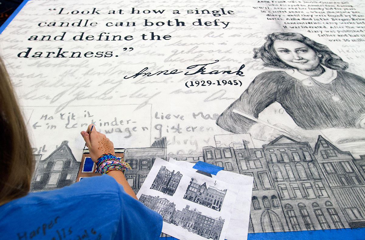 Lauren Simons of London, Ky., paints a mural in Nazi Germany and the Holocaust Friday, July 15. (Photo by Sam Oldenburg)