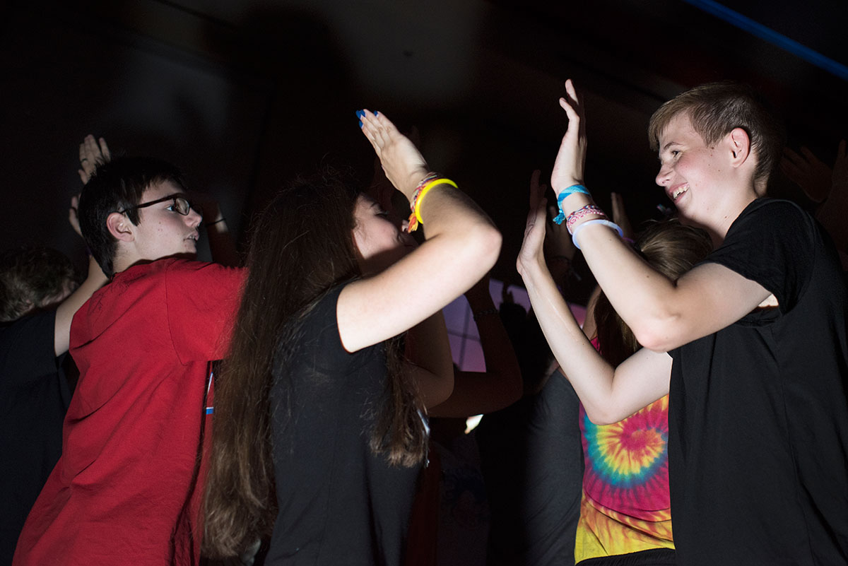 Here Emily Jones (center) from Lexington, and Stuart Kernohan from Bowling Green exchange high-fives during the dance Friday, July 15. (Photo by Tucker Allen Covey)
