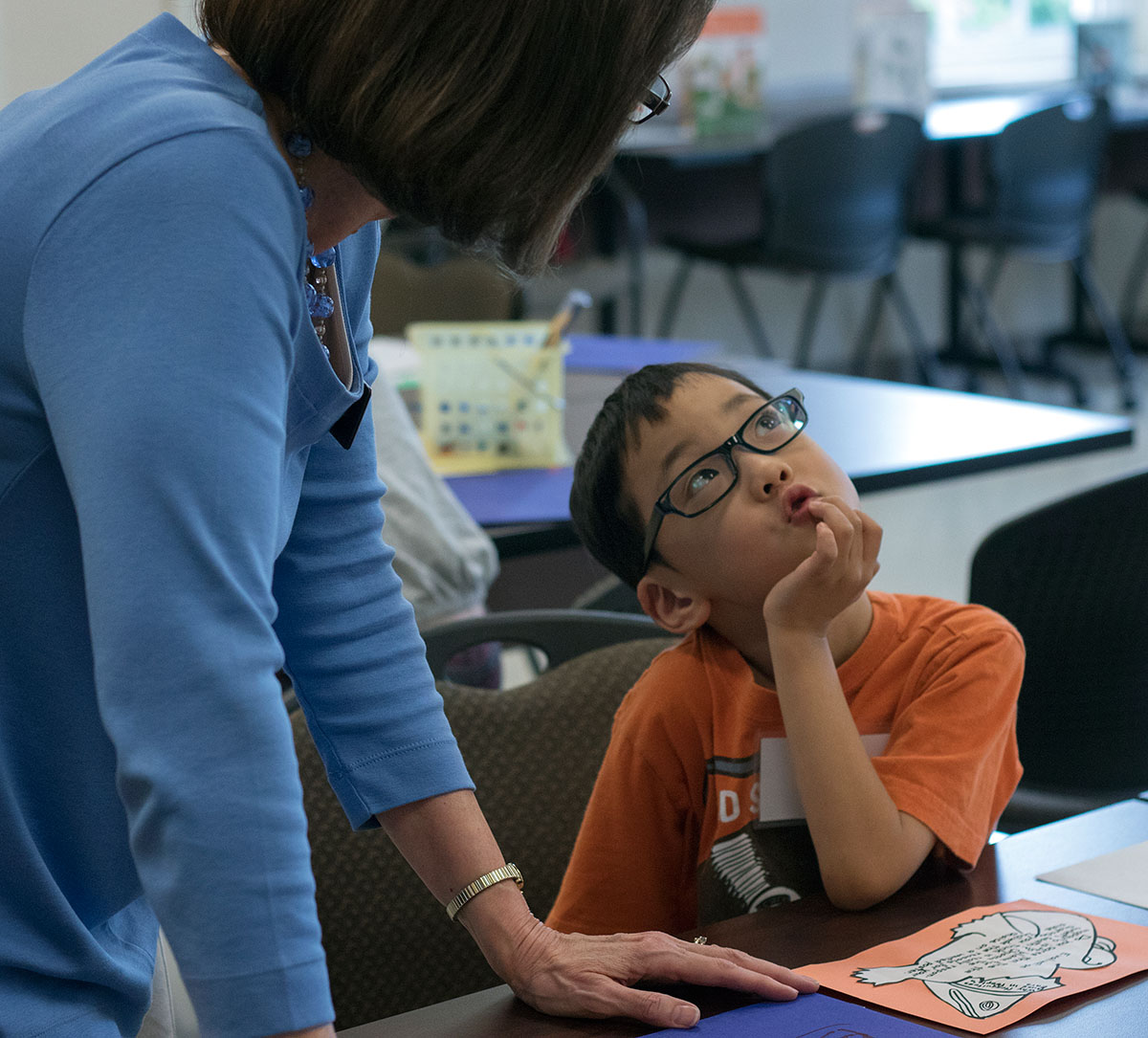 Grant Willis works with Language Arts teacher Mary Evans on a class project Tuesday, June 6. After reading a story, students completed one of four different creative projects. (Photo by Brook Joyner)