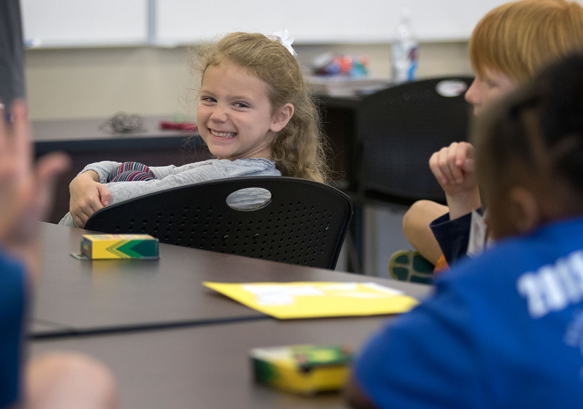 Morgan Jones laughs with her classmates during Math on Tuesday, June 6. After an introduction, Students worked with teacher Allison Bemiss to complete an experiment and record data. (Photo by Brook Joyner)