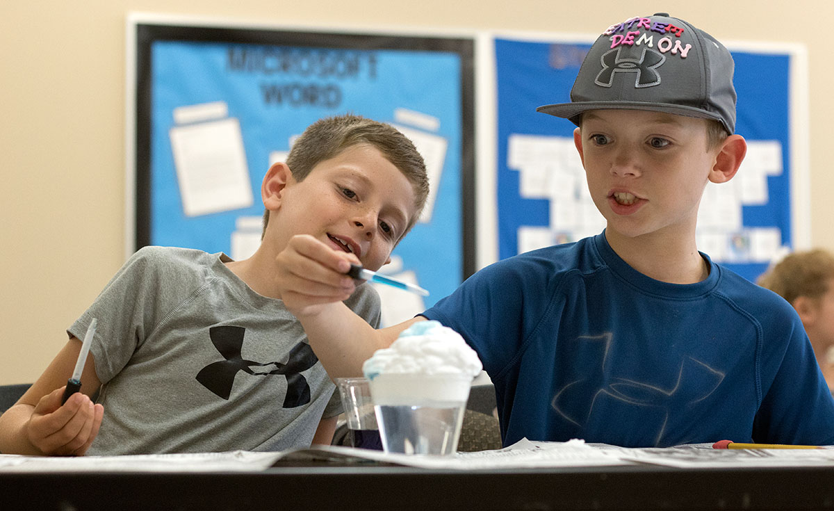 Reece Salyer (left) and Asa Bratcher complete an experiment during Science class Tuesday, June 6. After learning about the different types of clouds, students made their own clouds and rain using shaving cream, water, and food coloring. (Photo by Brook Joyner)