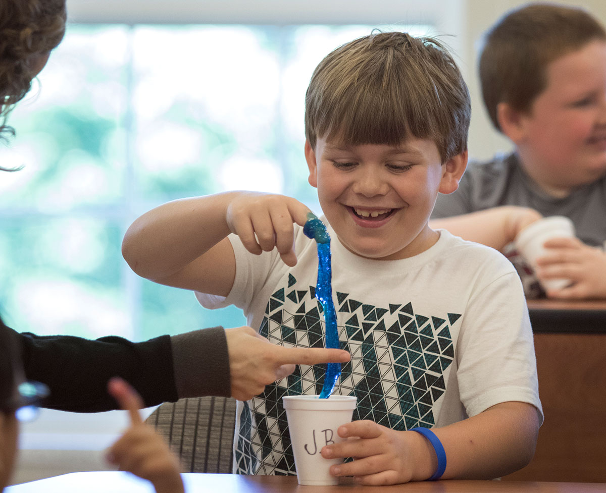 Jackson Braun plays with the slime he made as part of a guest scientist's presentation on Wednesday, June 7. Students combined substances to learn about different types of chemical reactions. (Photo by Brook Joyner)