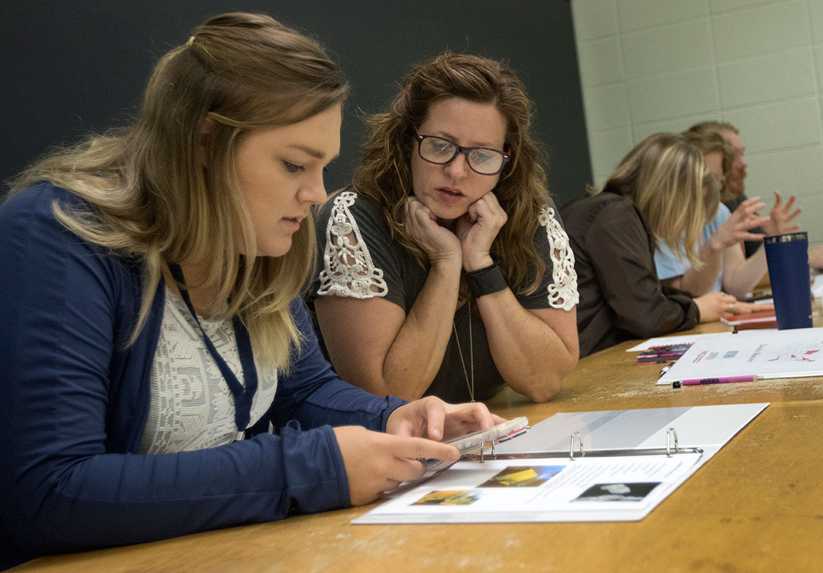 Katie Donlin (left) of Hayfield, Minn., and Donna Shartzer of Hardinsburg experiment with inexpensive alternatives to standard classroom microscopes on Monday, June 5. After learning about the alternatives, the NSCF Scholars built they own microscopes. (Photo by Brook Joyner)