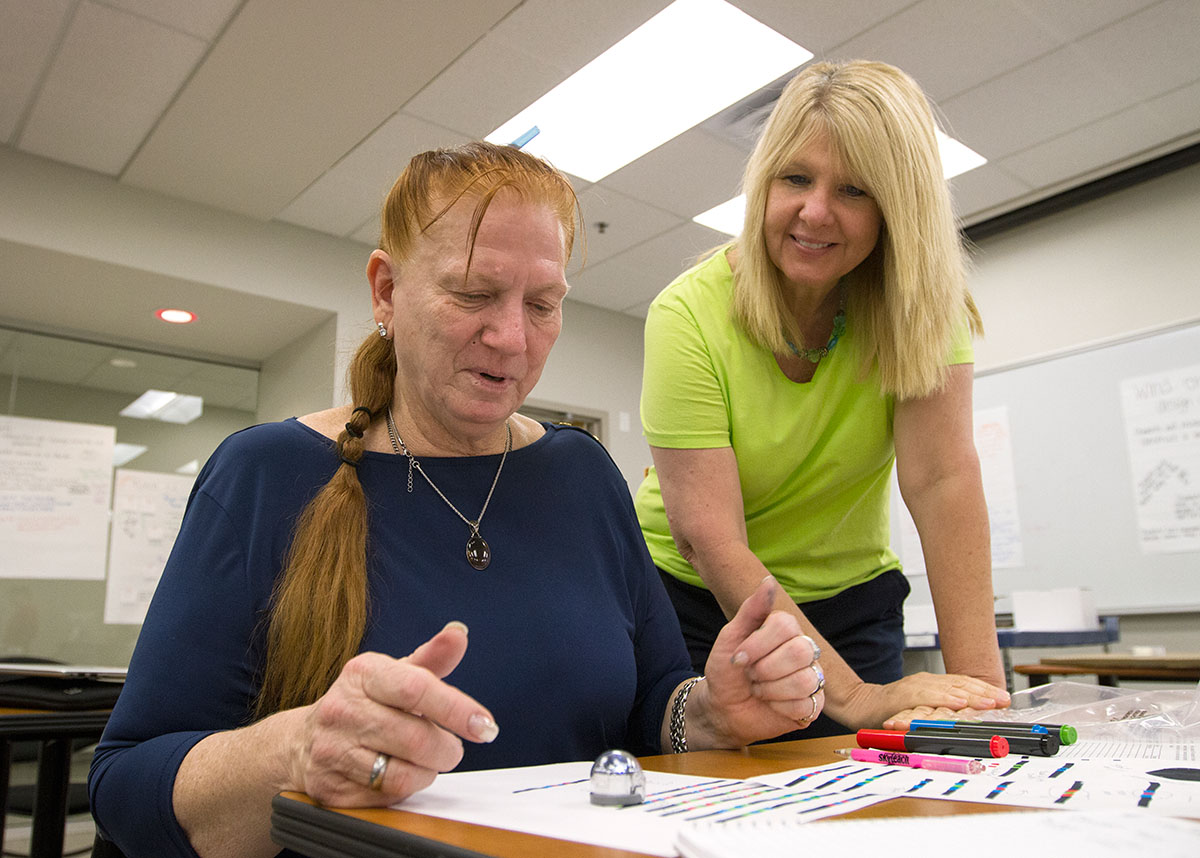 Suzanne Banas (left) from Miami codes her Ozobot with help from Kerrie McDaniel. A biology professor at WKU, Kerrie has taught life science lessons to the NSCF SCholars throughout the week. (Photo by Sam Oldenburg)