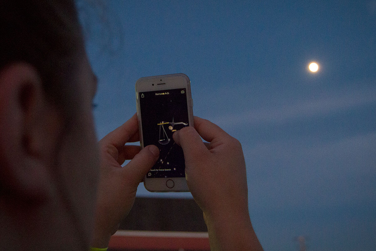 NSCF Scholar Katie Donlin from Hayfield, Minn., uses an iPhone app to find the locations of constellations Tuesday, June 6 at Chaney's Dairy Barn outside Bowling Green. The scholars used telescopes to look at the moon, Jupiter, and other points of interest. (Photo by Sam Oldenburg)