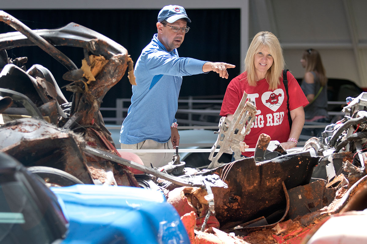 NSCF Scholar John Lui (left), of Dousman, Wis., and biology professor Kerrie McDaniel look at remains of the Corvettes that fell into the sinkhole at the National Corvette Museum Friday, June 9. The scholars toured the museum after conducting an experiment at the NCM Motorsports Park. (Photo by Brook Joyner)