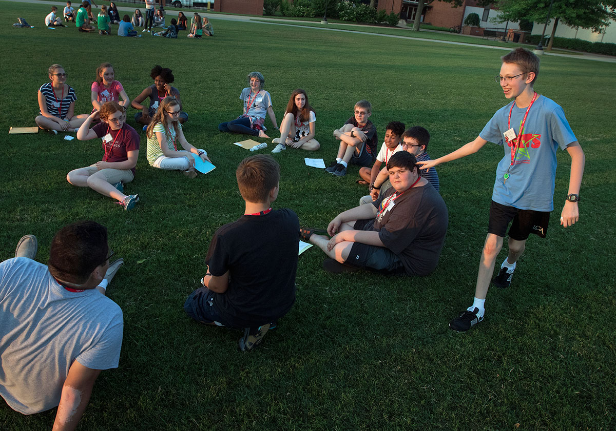 Chris Paris of Prospect plays a modified version of "Duck, Duck, Doose" with his group on Sunday, June 11. The counselors decided to make it "Fish, Fish, Dinosaur" as opposed to the traditional version. (Photo by Brook Joyner)