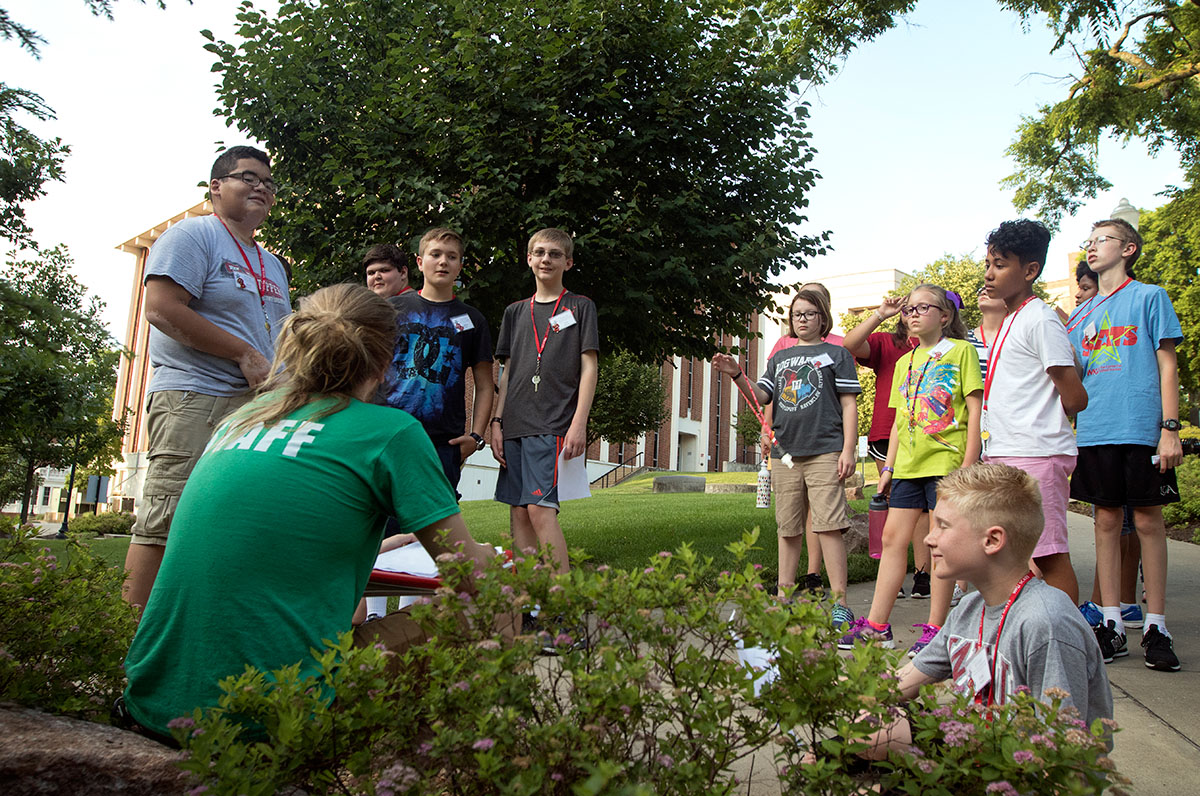 Counselor Jacob Couch talks with SCATS campers behind Florence Schneider Hall during a campus tour on the first evening of SCATS Sunday, June 11. The tour helped students learn where their classes would be during the next two weeks. (Photo by Brook Joyner)