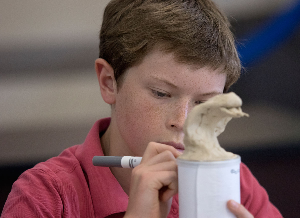 Jamie Campbell of Goshen works on his canopic jar in Art Through the Ages Wednesday, June 14. Each student chose an animal to mold for the top and then covered the rest in hieroglyphics. (Photo by Brook Joyner)