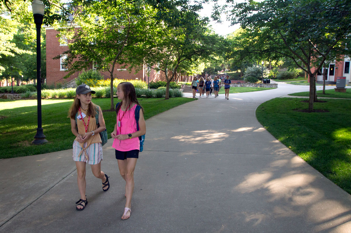 Mary Margaret Vickers (left) and Hayden Tichenor, both from Henderson, walk ahead of the rest of their counselor group on their way to Downing Student Union to eat breakfast Tuesday, June 13. (Photo by Sam Oldenburg)