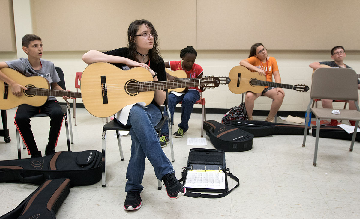 Veronica Walker of Elizabethtown listens as teacher Charles McManus explains the cords for the class to play in Guitar 101 Thursday, June 15. (Photo by Brook Joyner)