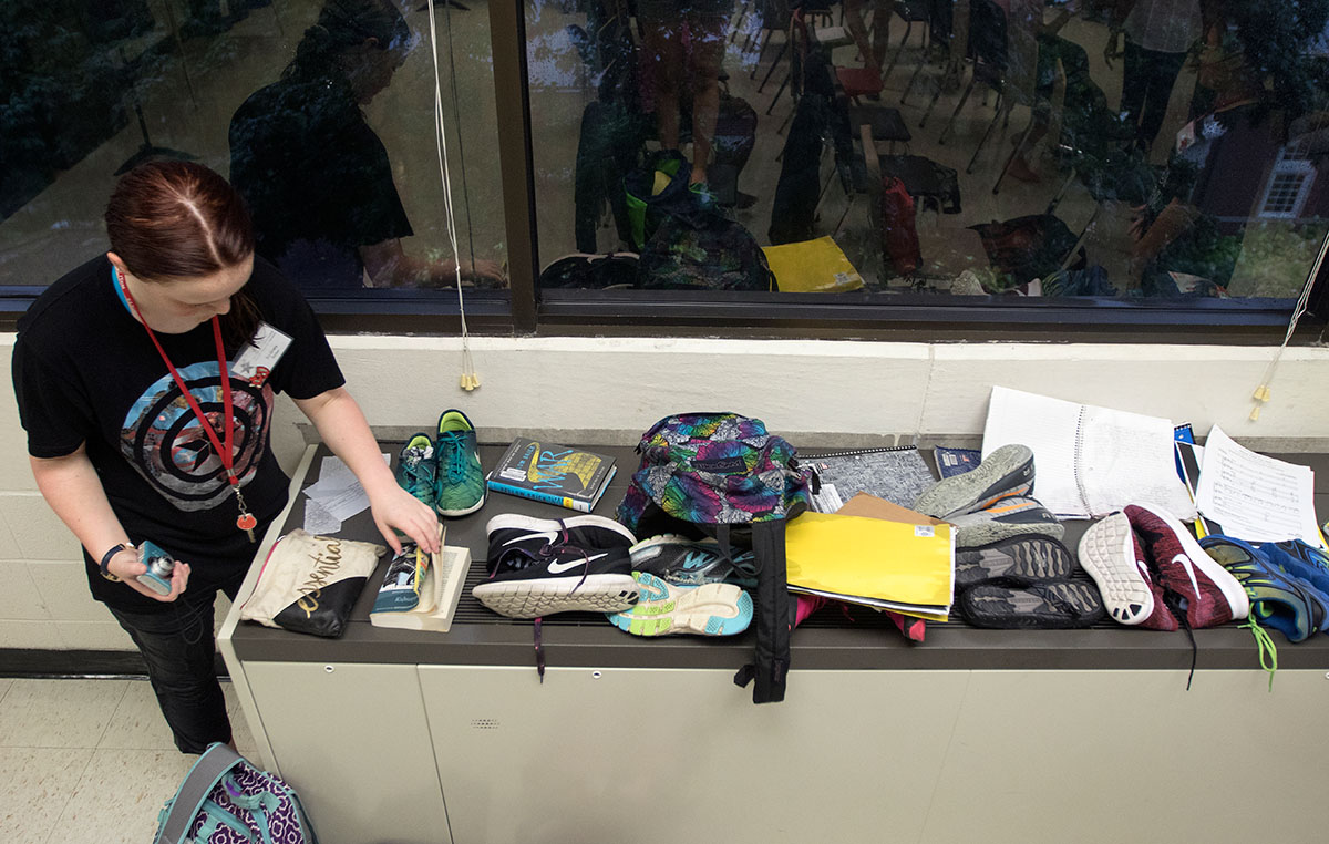 Sydney Badon of Louisville lays her book on the air conditioning unit to dry alongside classmates' belongings in Singing 101 Thursday, June 15. After getting caught in a rainstorm, many students spent the class barefoot as their shoes and socks dried out. (Photo by Brook Joyner)