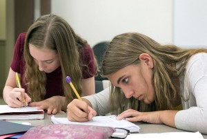 Ava Coffman (left) and Zoe Baker, both of Bowling Green, work on a project in Government and Economics Monday, June 19. Ava worked on their country's flag design while Zoe wrote the country's constitution. (Photo by Brook Joyner)