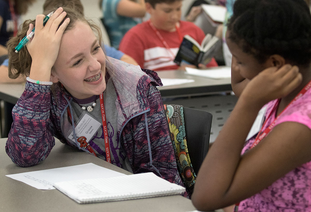 Grace Spears (left) of Franklin reads her story to Aneesha Edwards of Lexington in Future Authors Thursday, June 15. The class was challenged to write a short story without repeating any words. (Photo by Brook Joyner)