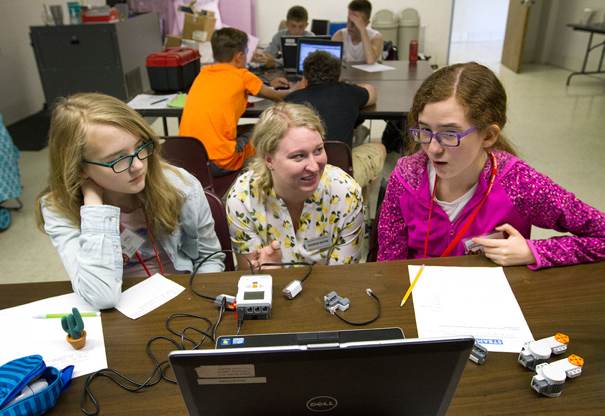 STEAM Labs teacher Madison Moore helps Emmy Rastoder (left) and Sachi Barnaby, both from Bowling Green, figure out how to program their Lego robot Wednesday, June 28. (Photo by Sam Oldenburg)