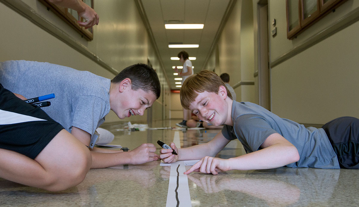 Will Faulkner (left) of New Haven and Max Roberts of Louisville draw a line for their Ozobot to travel during From Mars to Mutations Wednesday, June 21. (Photo by Sam Oldenburg)