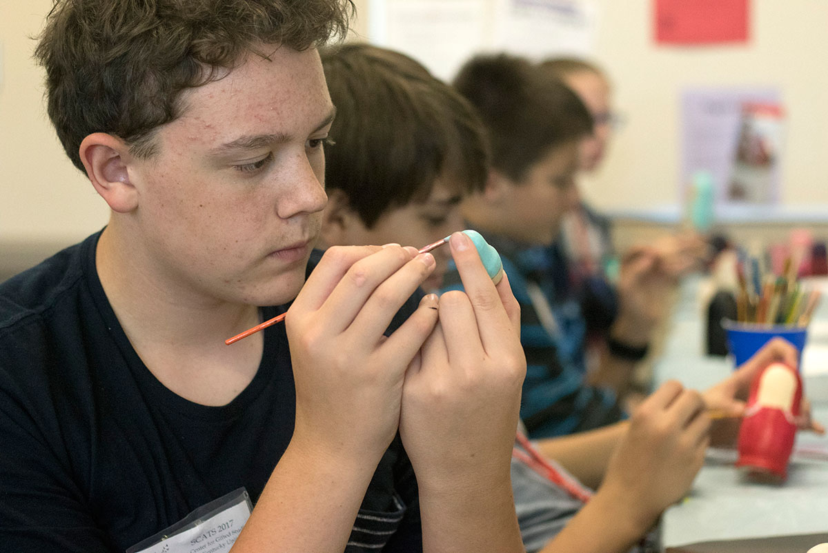 Cole LaDow of LaGrange paints a Russian nesting doll in Discover Russia Thursday, June 22. Each student designed his or her own set of dolls. (Photo by Brook Joyner)