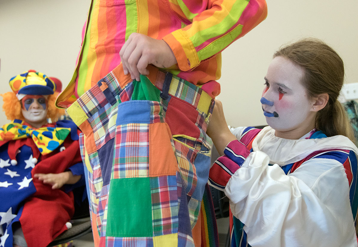 Eden Casebier of Bowling Green helps Lily Simpson, also of Bowling Green, with her costume in Clowning Friday, June 23. Each student designed and applied their face makeup before picking out an outfit to wear. (Photo by Brook Joyner)