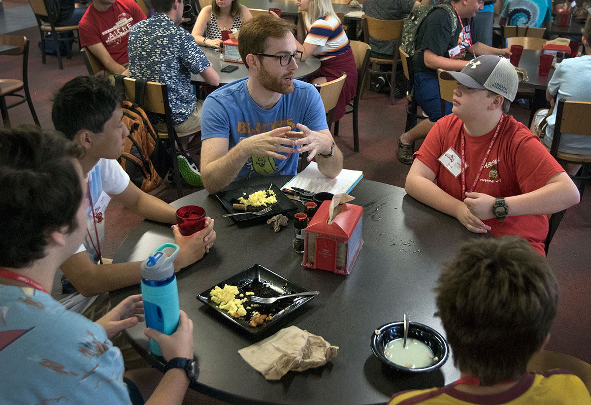 Max Tague (center) talks with Chase Whitman of Leitchfield and other campers during breakfast in Fresh Food Company Monday, June 26. (Photo by Brook Joyner)