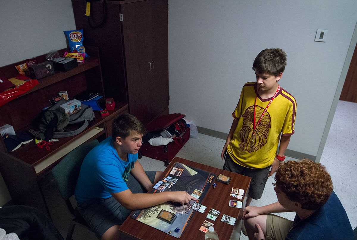 Dawson Wilcox (from left) of Greenville, Ala., teaches Thatcher Balfour of Fort Campbell and Tommy Pack of Frankfort how to play Magic the Gathering during hall time in his room in McLean Hall Monday, June 26. (Photo by Sam Oldenburg)