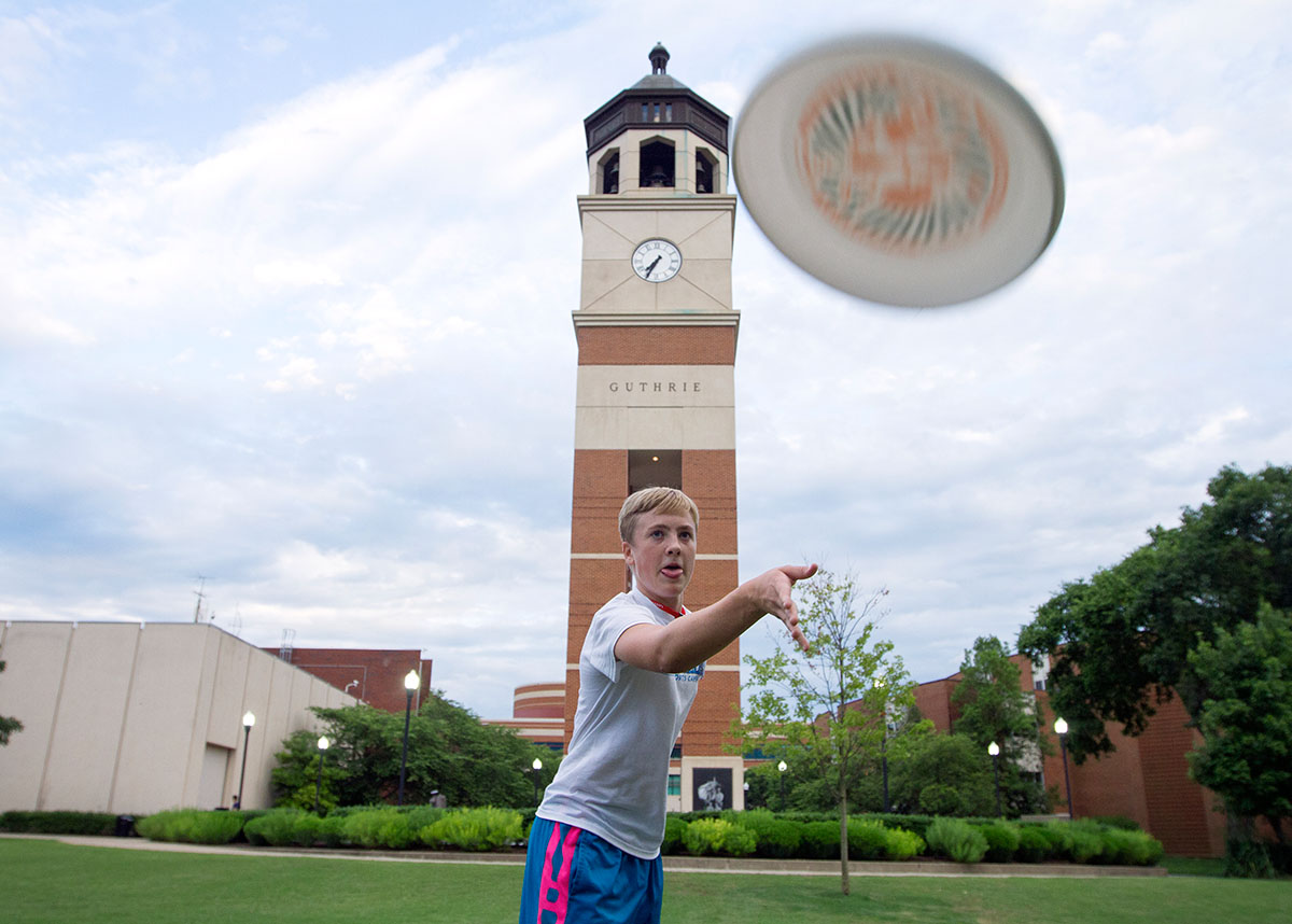 Teague Howell tosses a frisbee to a teammate while playing Ultimate Frisbee on South Lawn during optional time Monday, June 26. (Photo by Sam Oldenburg)