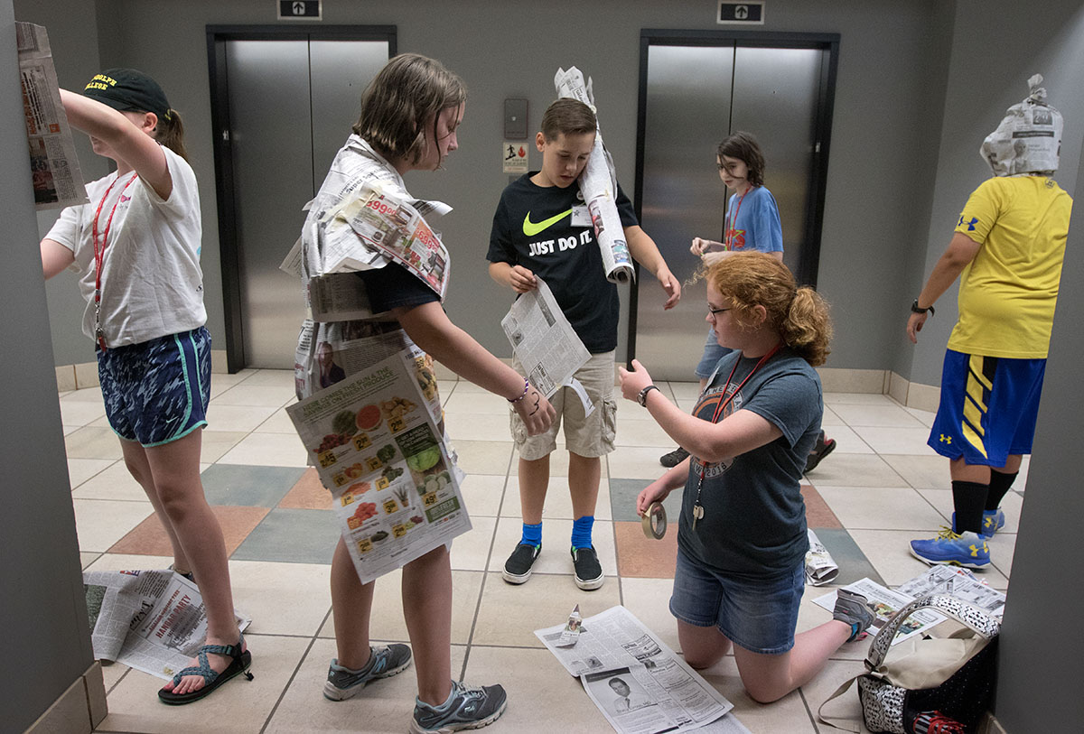 Campers put together costumes and props before their performance of "Beauty and the Beast" during Paper Theater Saturday, June 17. The only materials available to use were newspaper and tape. (Photo by Brook Joyner)